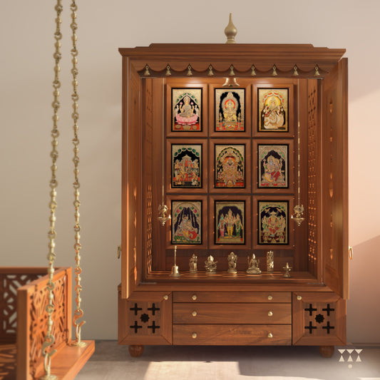 A solid wood mandir with pure brass bells, Tanjore art prints, cutwork designs and storage, tinted in an almond brown color