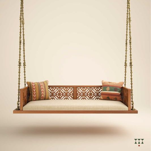 A handcrafted wooden swing with a cutwork pattern, tinted in almond brown with a decorative brass chain with animal motifs