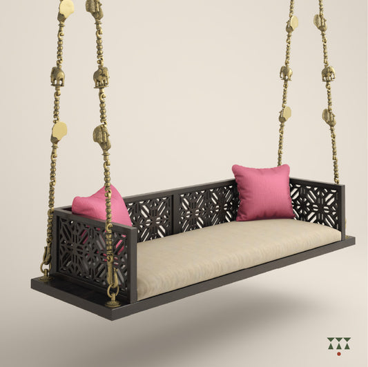 A wooden swing with cutwork, tinted in slate black with a decorative brass chain and animal motifs, fabric seat and cushions