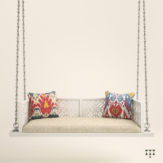 A handcrafted wooden swing with cutwork, tinted in snow white with a decorative brass chain in a sliver finish