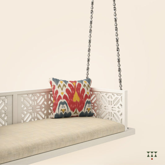 A handcrafted wooden swing with cutwork, tinted in snow white with a decorative brass chain in a sliver finish