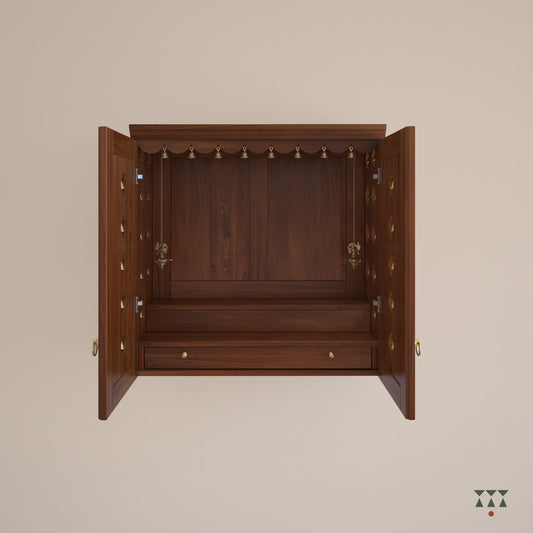 A solid wood mandir with doors, pure brass bells, accessories, cutwork designs and storage tinted in almond brown