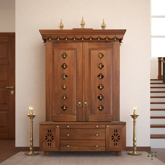 A solid wood mandir with doors, pure brass bells, accessories, cutwork designs and storage, tinted in an almond brown color