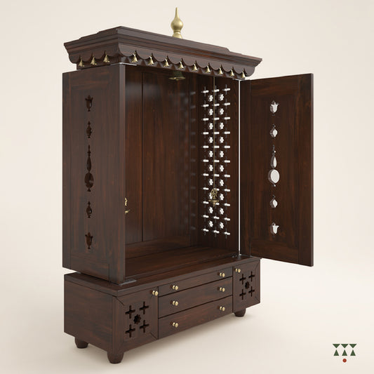 A solid wood mandir with doors, pure brass bells, accessories, cutwork designs and storage, tinted in a tamarind brown color
