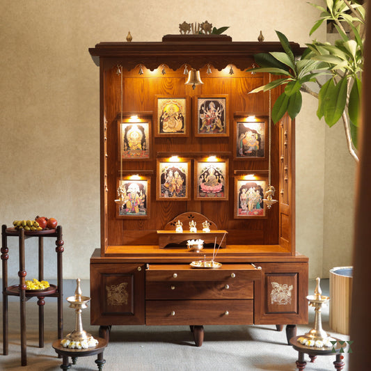 An open wooden mandir with tanjore paintings and pooja accessories