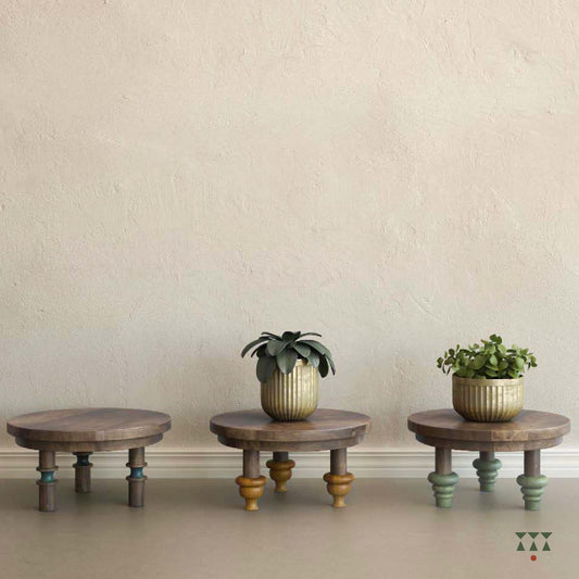 Plants displayed on a set of 3 low, solid wood accent tables with turned legs and contrasting tints