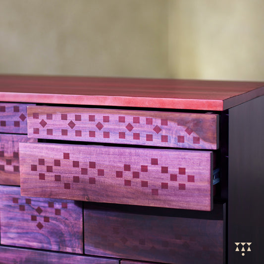 Solid wood chest of drawers with a purple tinted facade patterned with Bandhani textile dots in red