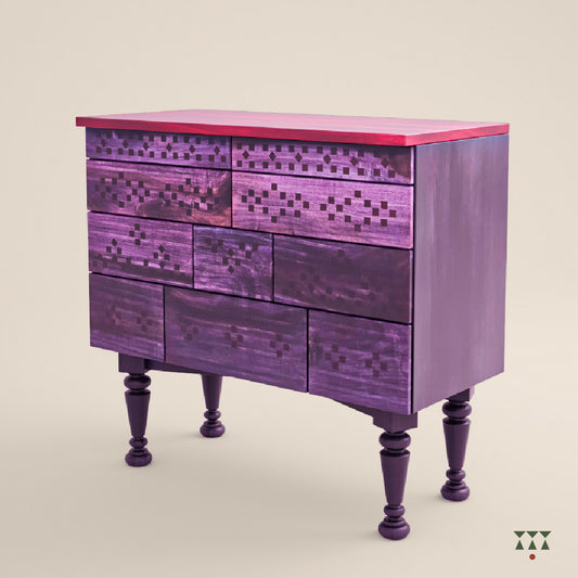 Solid wood chest of drawers with a vibrant, purple tinted facade inspired by Indian textiles on a neutral background