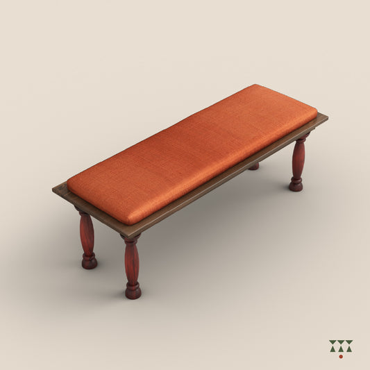 A solid wood bench with turned legs in a saffron orange tint and a cushioned seat upholstered in luxurious silk fabric
