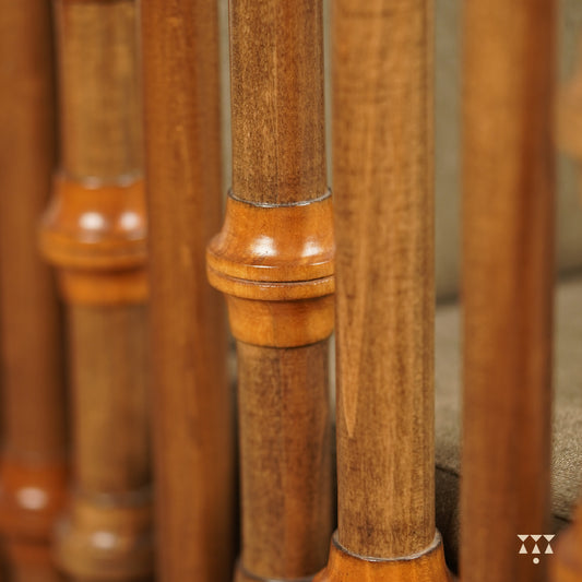 A close up of multiple turned spindles that make the armrest of a solid wood statement armchair