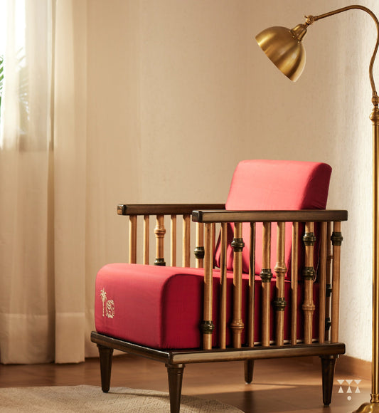 A solid wood statement chair with the arm and backrest made of multiple turned spindles, upholstered in rich colorful silk