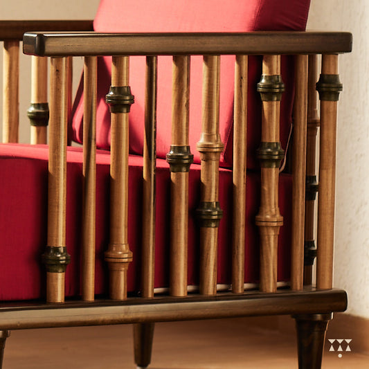 A close up of multiple turned spindles that make the armrest of a solid wood statement armchair