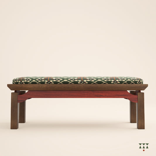 An artisanal solid wood bench with an upholstered seat in a printed Kilim fabric and legs in a tinted accent color