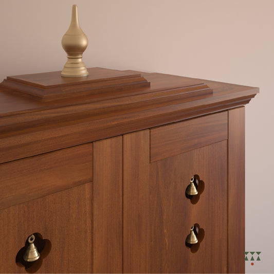 A solid wood mandir with doors, pure brass elements, cutwork designs and storage, tinted in almond brown