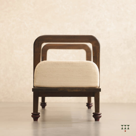 Close up of a sculpted long wooden bench upholstered in beige silk, tinted in Mocha Brown with a Beet Red accent