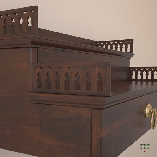 A compact wooden, wall mounted Mandir with steps, cutwork, storage and pure brass elements tinted in tamarind brown
