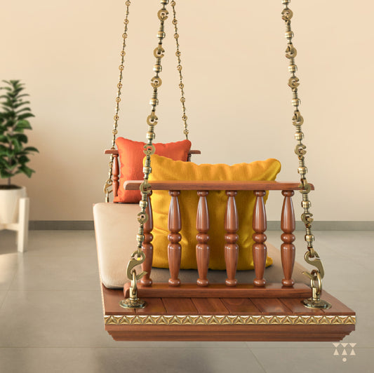 A solid wood swing with turned armrests, tinted in almond brown with decorative brass chains, a fabric seat and cushions