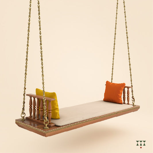 A solid wood swing with turned armrests, tinted in almond brown with decorative brass chains, a fabric seat and cushions