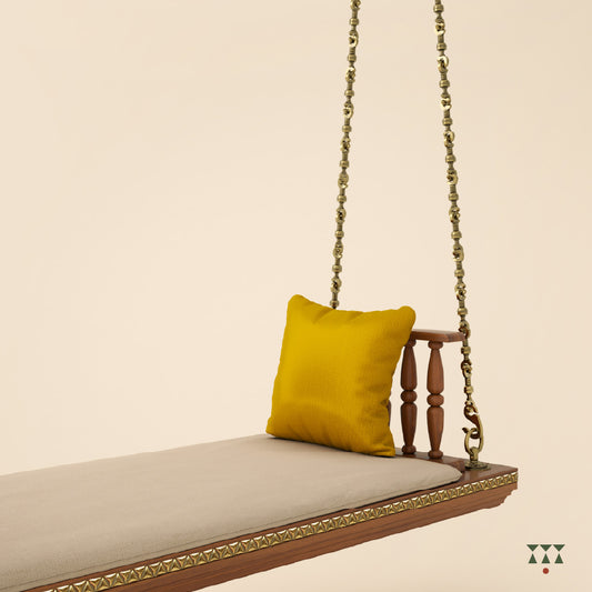 A solid wood swing with turned armrests, tinted in almond brown with decorative brass chains, a fabric seat and cushions