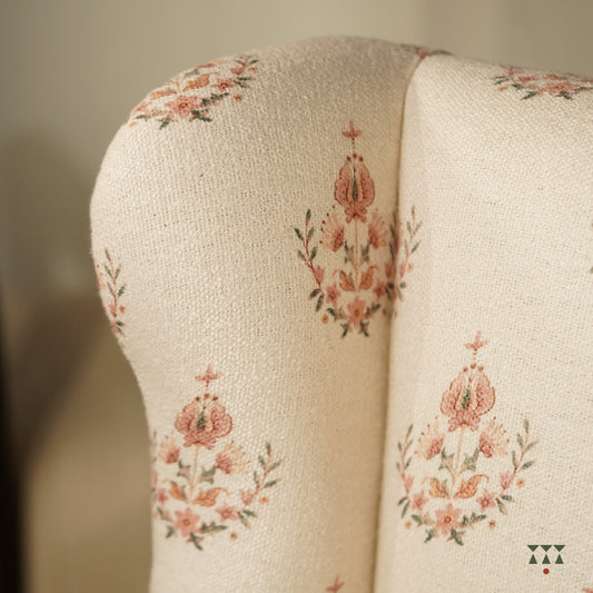 Close up of a floral printed white fabric of a solid wood wing chair