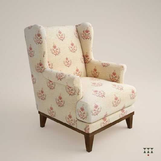 A solid wood wing chair draped in a floral printed white fabric with a matching cushion, tinted in mocha brown