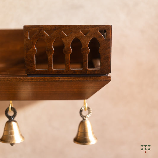 Cut out details of wooden Wall mounted temple shelf with brass bells