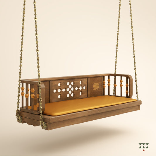 Close up of a wooden swing with Kolam, Annapakshi and floral designs and turning details on the backrest with a fabric seat