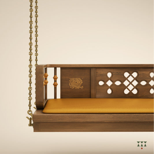 Close up of a wooden swing with Kolam, Annapakshi and floral designs and turning details on the backrest with a fabric seat