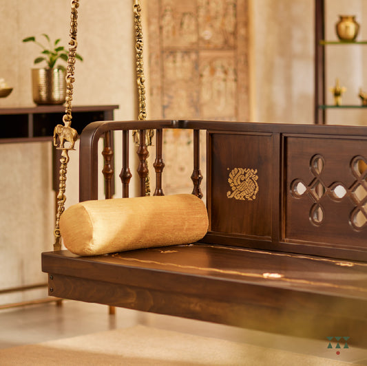 A wooden swing crafted with Kolam, Annapakshi and floral designs on the backrest and seat with pure brass animal motif chains