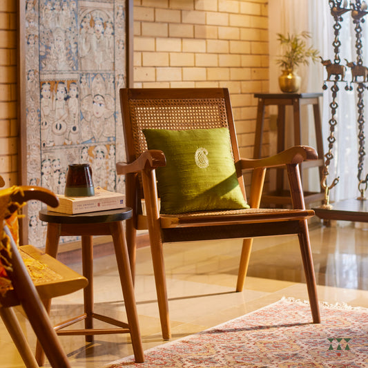 Solid wood armchair with a woven back and seat tinted in desert brown with a green silk embroidered cushion