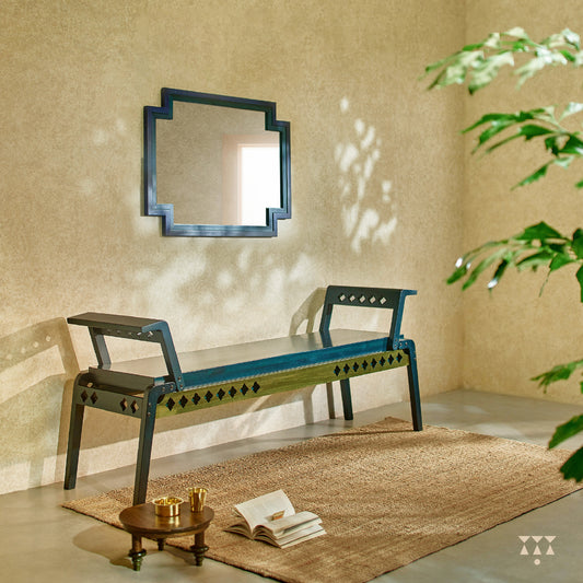 A solid wood bench that blends sharp geometry and cutwork with soft edges, tinted in Deep Blue with Moringa Green accent