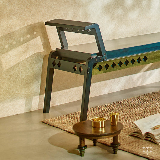 Close up of the sharp geometry and cutwork of a wooden bench, tinted in Deep Blue with Moringa Green accent