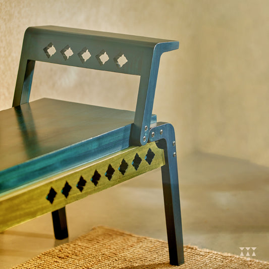Close up of the sharp geometry and cutwork of a wooden bench, tinted in Deep Blue with Moringa Green accent