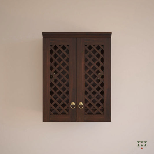 A solid wood, wall mounted Mandir with doors, brass accessories and storage to house idols. Tinted in tamarind brown.