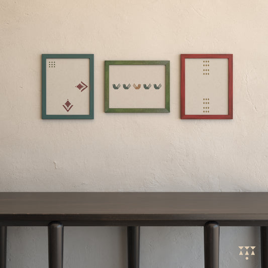 Set of 3 large wooden frames tinted in beet red, moringa green & lagoon blue placed on a wall above a console table