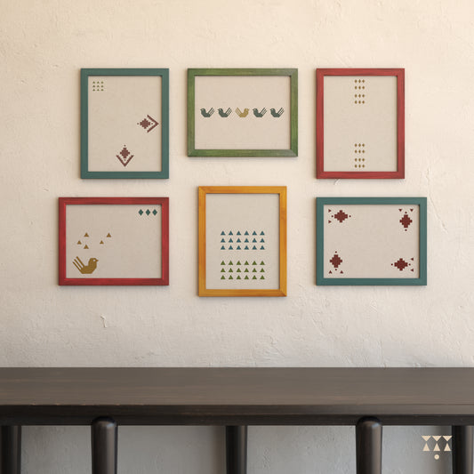 Set of 6 large wooden frames tinted in Beet Red, Moringa Green, Lagoon Blue & Mustard Yellow on a wall above a console table