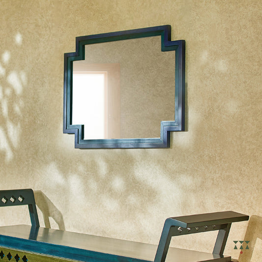 A large wall mirror with unique inverse edges layered with blue accents, handcrafted in solid wood