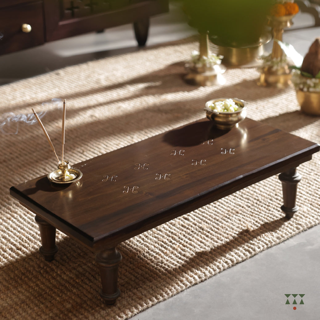Low, solid wood platform with etched Kolam patterns as part of the pooja room set