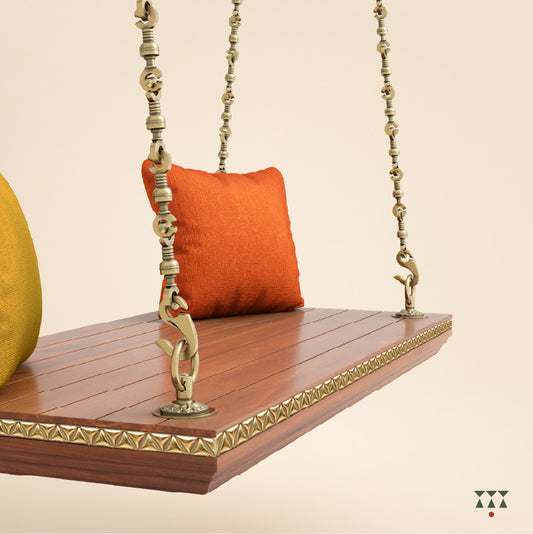 A handcrafted wooden swing base tinted in almond brown with decorative edging, brass chains and cushions