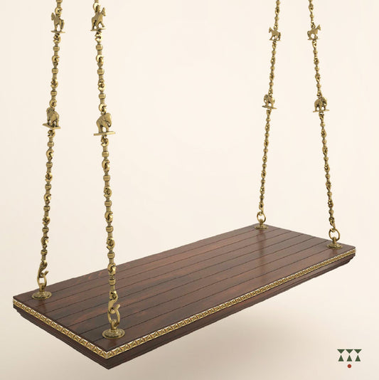 A handcrafted wooden swing base tinted in tamarind brown with decorative edging and brass chains with animal motifs