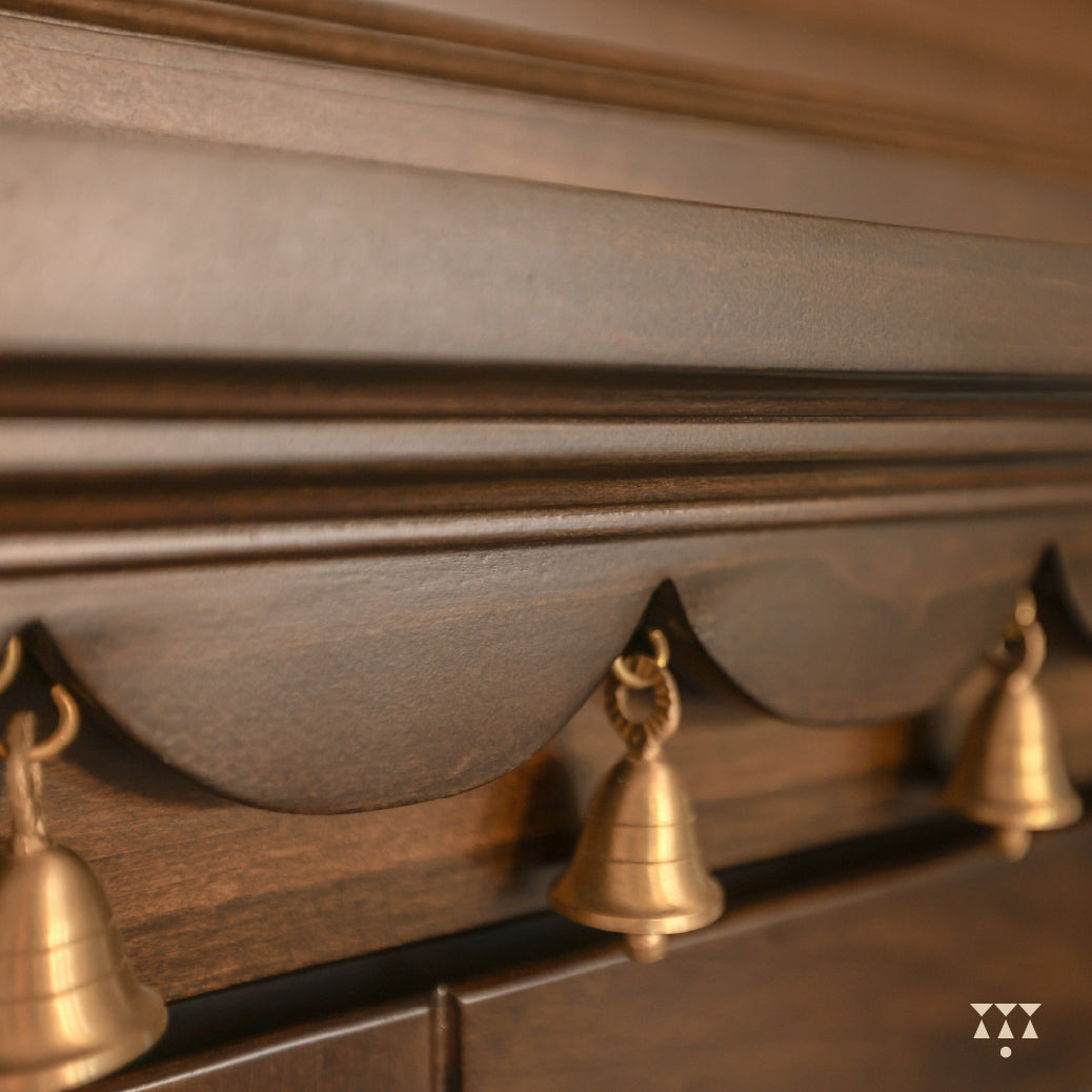 Close-up of the Vikat temple solid wood top surface with hanging brass bells