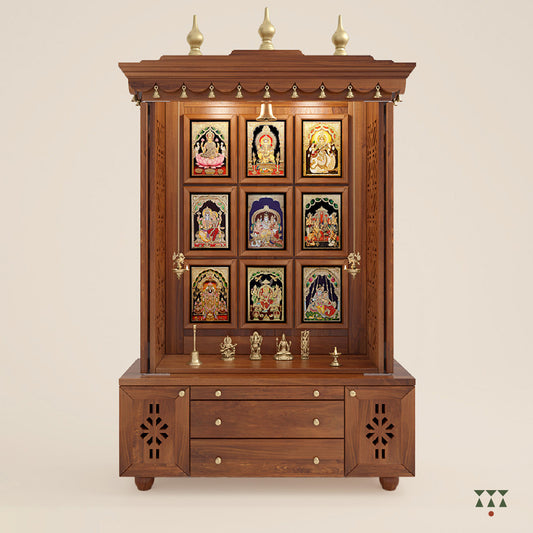 A solid wood mandir with pure brass bells, Tanjore art prints, cutwork designs and storage, tinted in an almond brown color