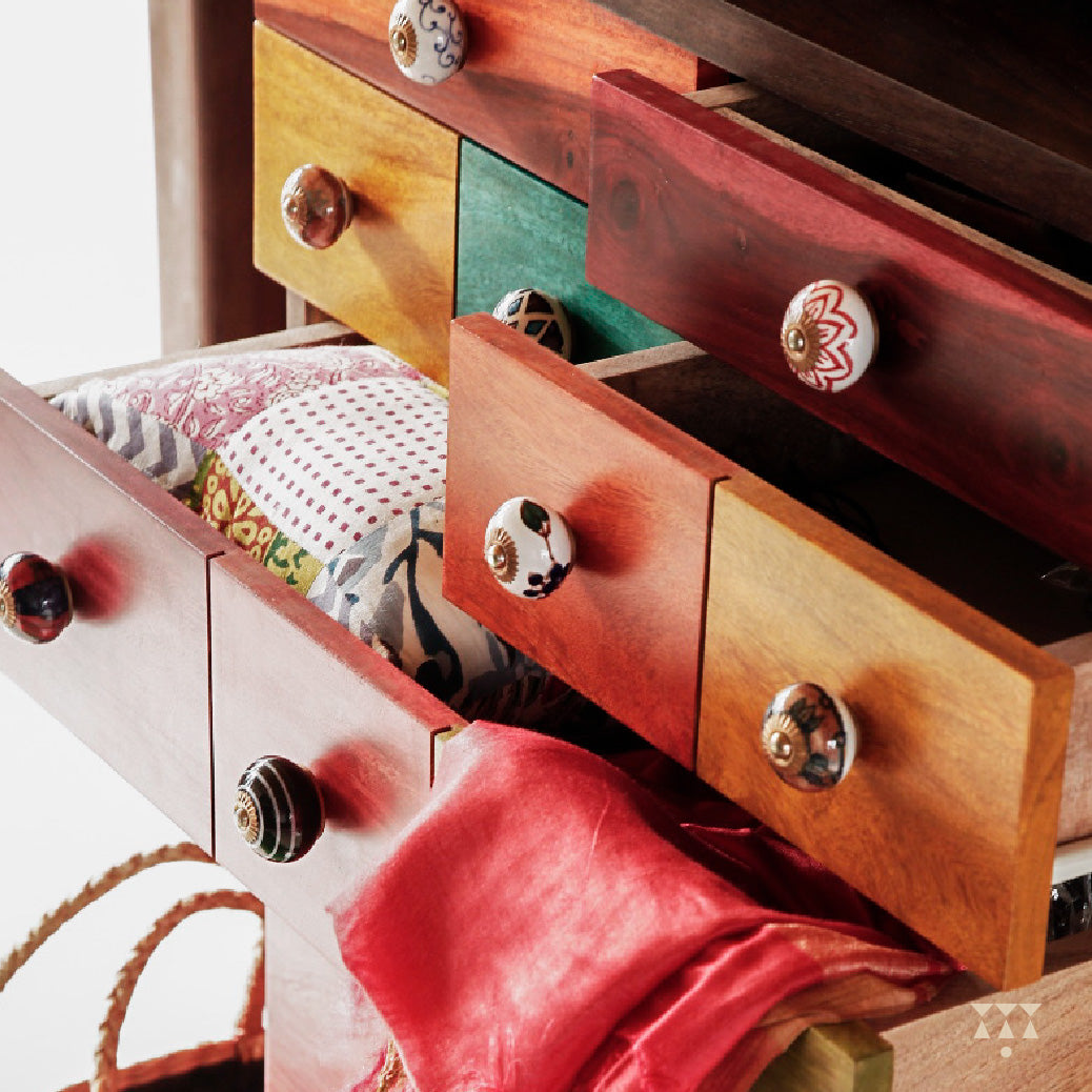 Colorful drawers of a chest of drawer with handmade ceramic knobs