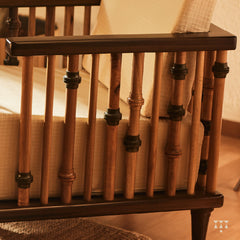 A close up of multiple turned spindles that make the armrest of a solid wood statement armchair