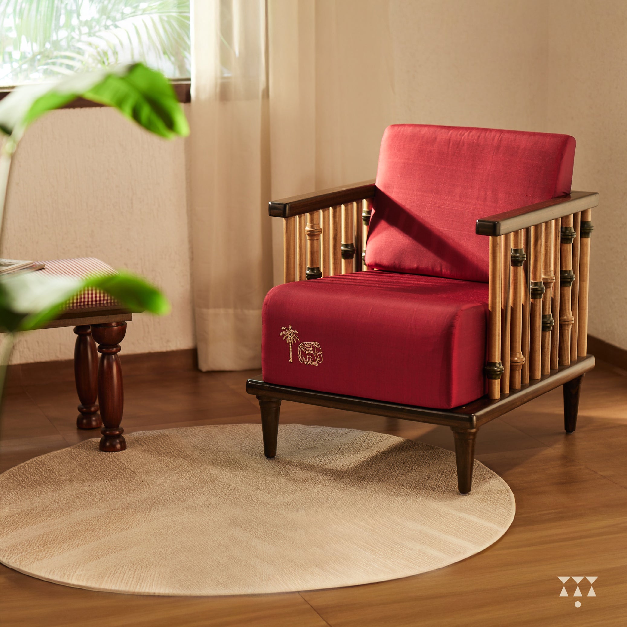 A solid wood statement chair with the arm and backrest made of multiple turned spindles, upholstered in rich colorful silk