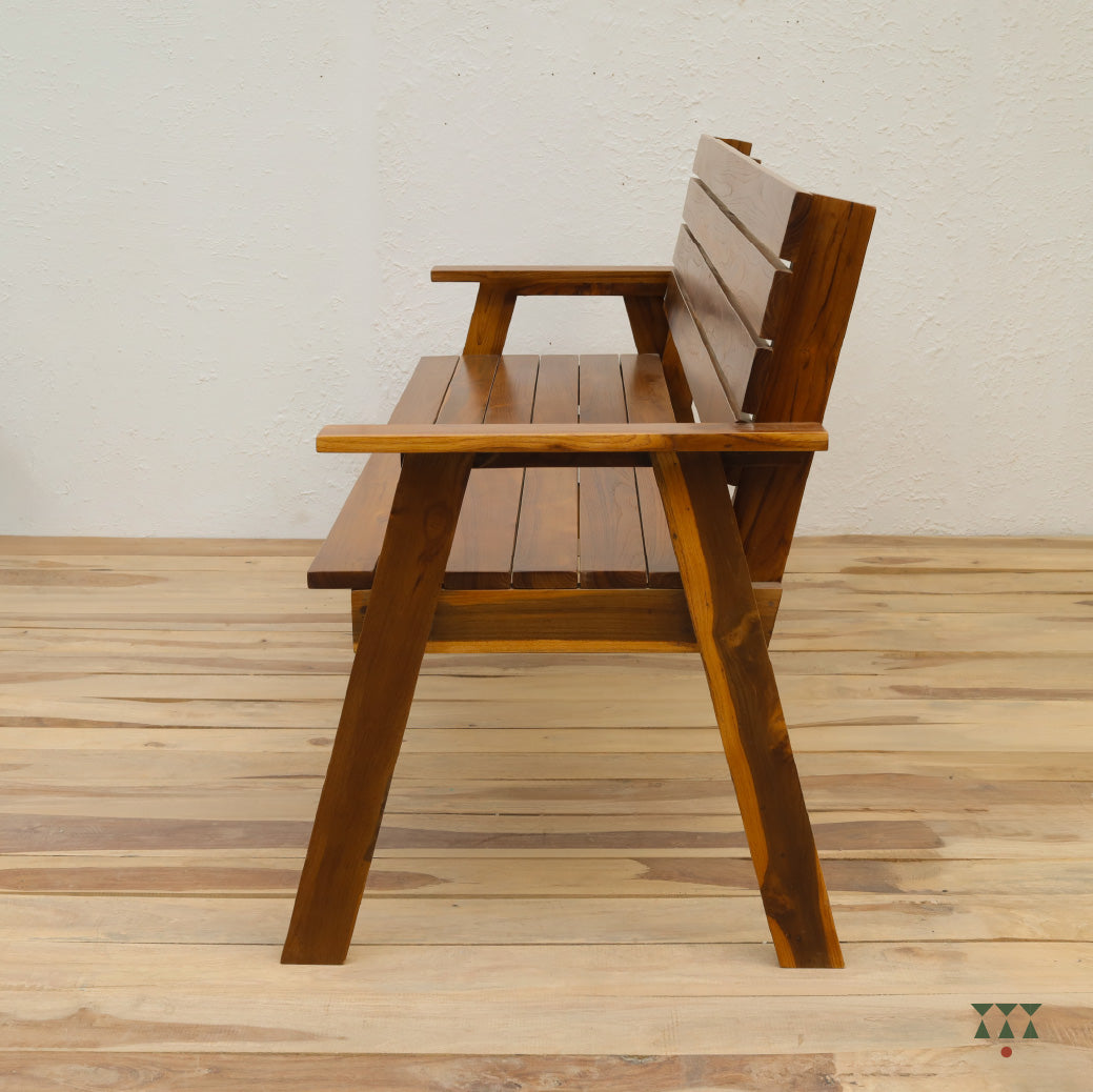 Wooden bench with armrests on a wooden floor against a white wall