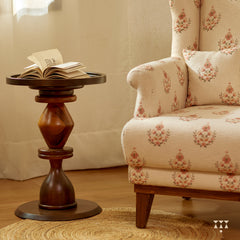 A solid wood wing chair draped in a floral printed white fabric with a matching cushion, tinted in mocha brown