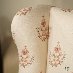 Close up of a floral printed white fabric of a solid wood wing chair