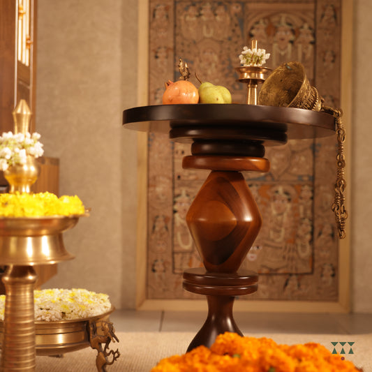 A solid wood side table with a circular top and a sculptural body tinted in Mocha Brown with a Mustard Yellow accent