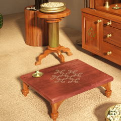 Wooden table with kolam design on a beige carpet